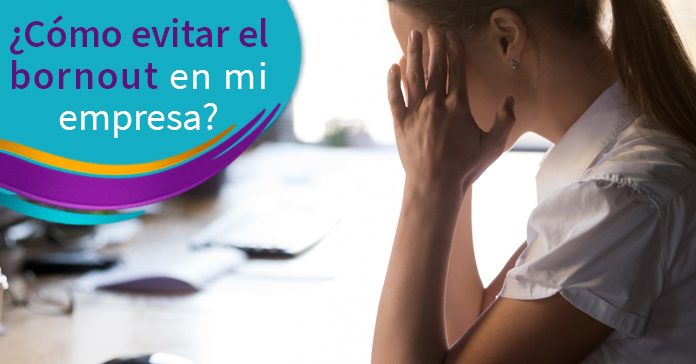 Mujer ejecutiva tocando su cabeza en señal de preocupación, sentada recargando codos sobre una mesa de trabajo, fondo de escritorio desenfocado